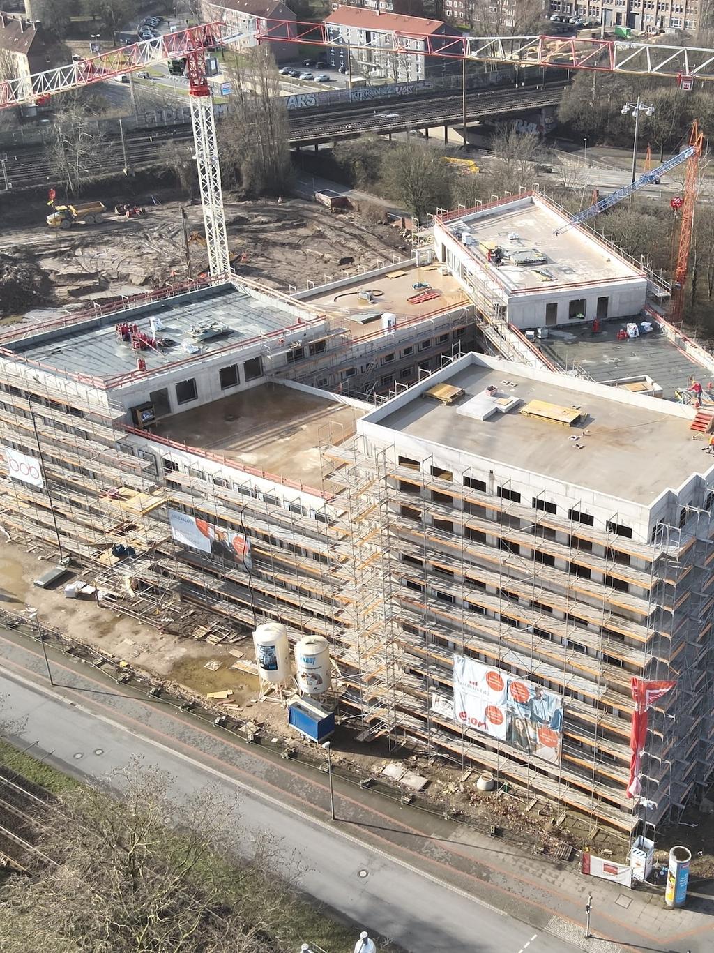 Luftaufnahme einer Baustelle mit Kränen und einem Gebäude im Bau